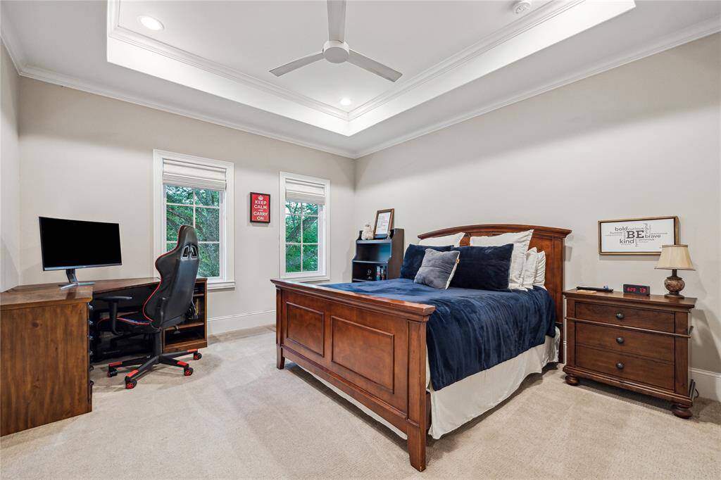 This spacious bedroom is complemented by an ensuite bathroom, offering privacy and convenience. Large windows allow natural light to fill the room, while the walk-in closet with custom built-ins provides ample storage.