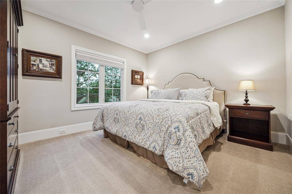 This cozy bedroom features plush carpeting for added comfort, with large Anderson windows that fill the room with natural light.