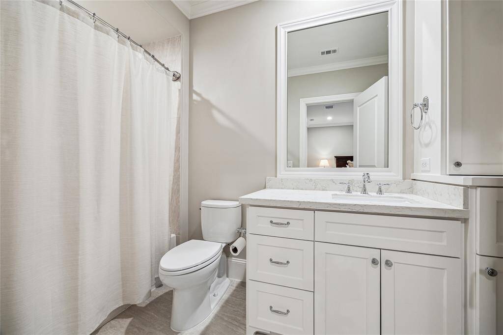 This well-appointed bathroom features a tub/shower combo, offering flexibility for both relaxing baths and quick showers. With sleek countertops and custom cabinetry.