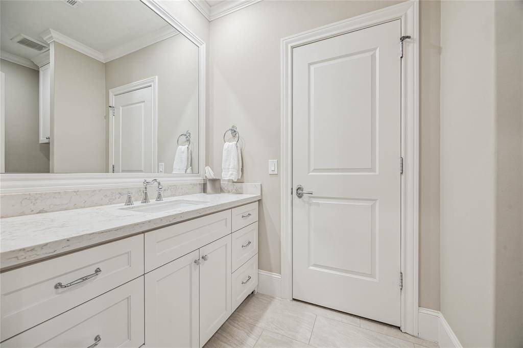 This well-designed bathroom features a tub/shower combo, sleek countertops, and custom cabinets, offering both style and practicality.