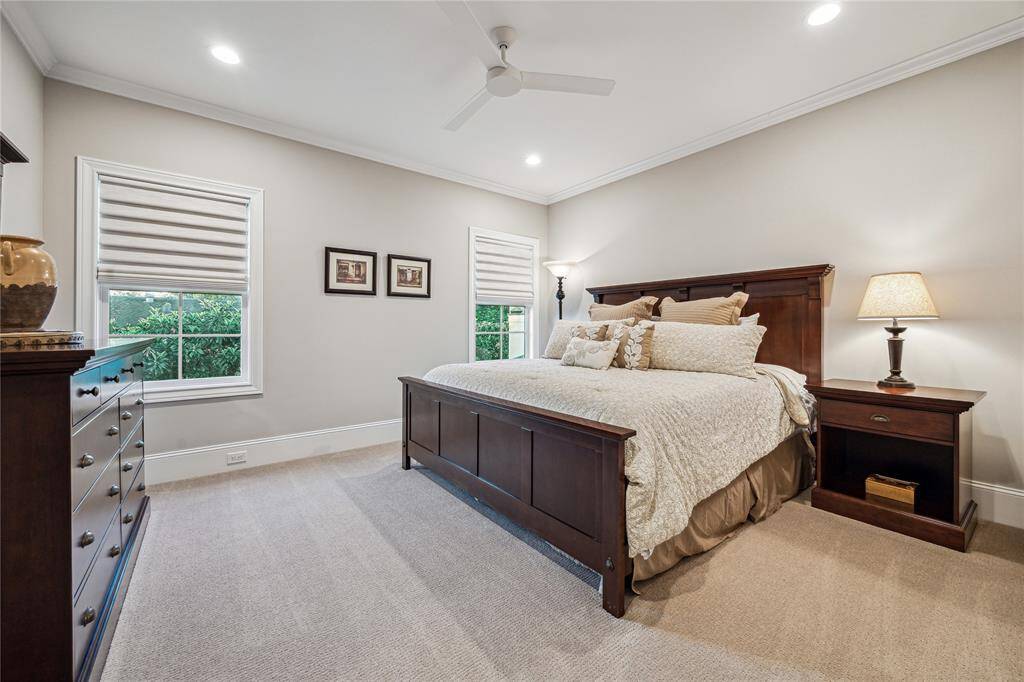 There are three spacious bedrooms located upstairs, each offering plush carpeting and ample natural light from large Anderson windows. These bedrooms are designed with comfort and functionality in mind, featuring walk-in closets with custom built-ins for plenty of storage.
