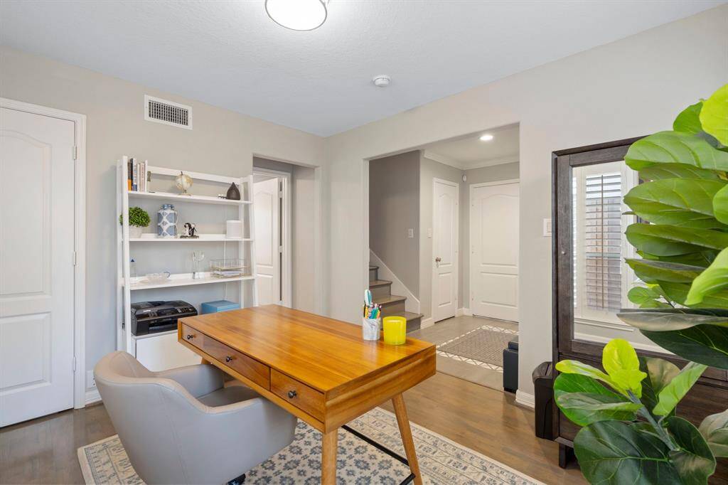 Another view of the home office located on the first floor. The hallway to the left leads to the bedroom with en-suite bath and outdoor access.