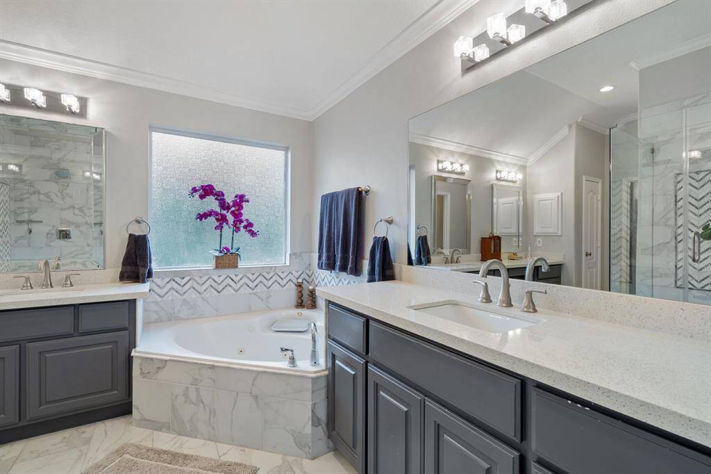 Large primary bathroom with jetted tub, large walk in shower and his and her sinks.