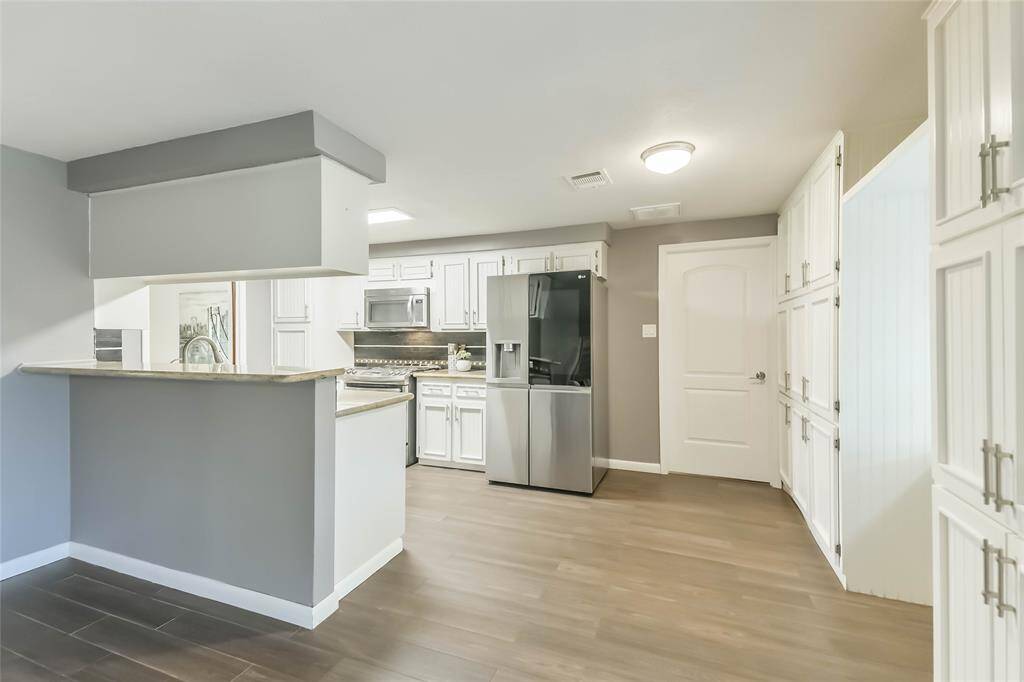 Sleek white cabinets, granite and mosaic tile backsplash.