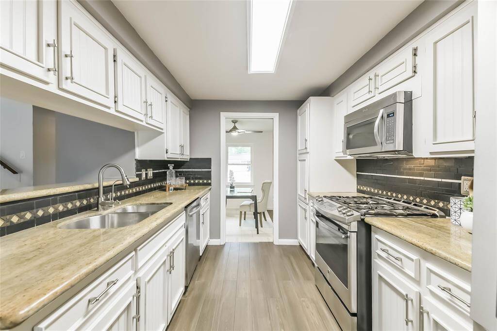 High end granite and mosaic tile backsplash accent the white cabinetry. Undermount sink, gas stove, built in microwave!