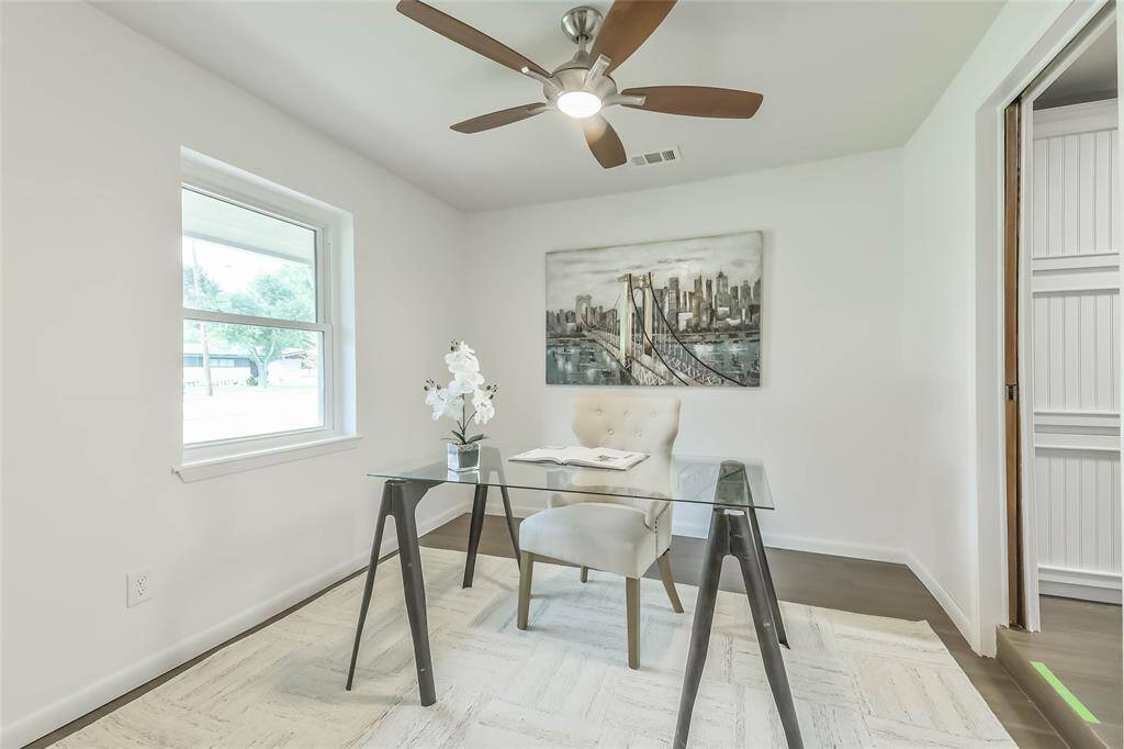 The space currently used as an office is just off the kitchen. Updated ceiling fan and tile "wood" floors. This is a good place to note the energy efficient double pane windows.