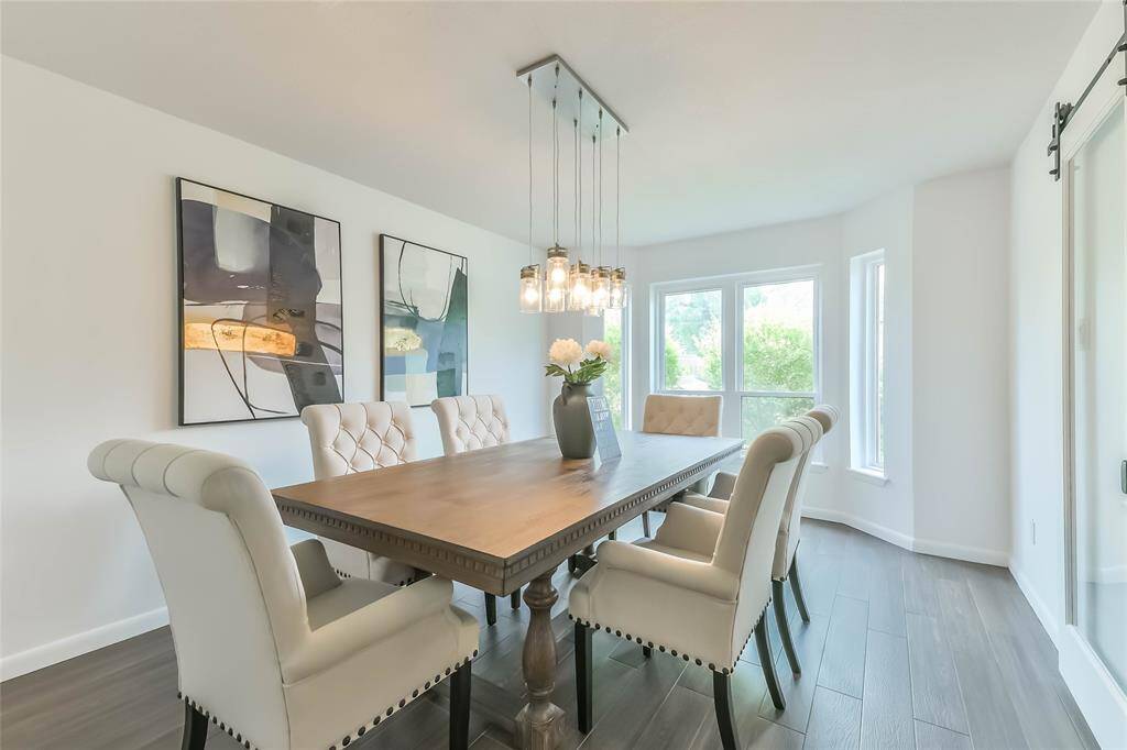 The spacious dining room has a bay window and is filled with natural light. Tile "wood" floors and updated lighting.
