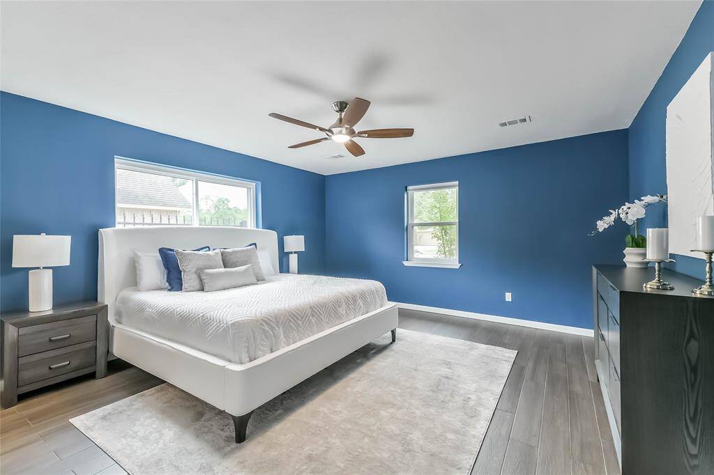SPACIOUS primary bedroom will hold your Texas sized furniture! Double pane, energy efficient windows help keep the room peaceful and quiet. When you come visit, check out the unique canvas paintings that were designed to cover the windows over the bed!