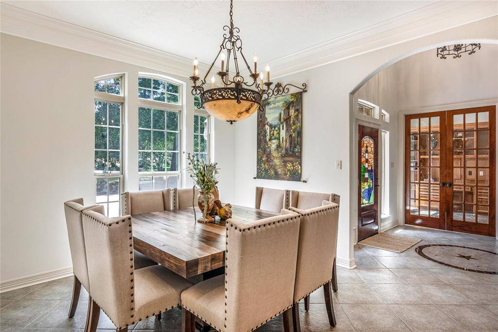 Bright dining area with large windows. The space opens to a welcoming foyer with stained glass accents.