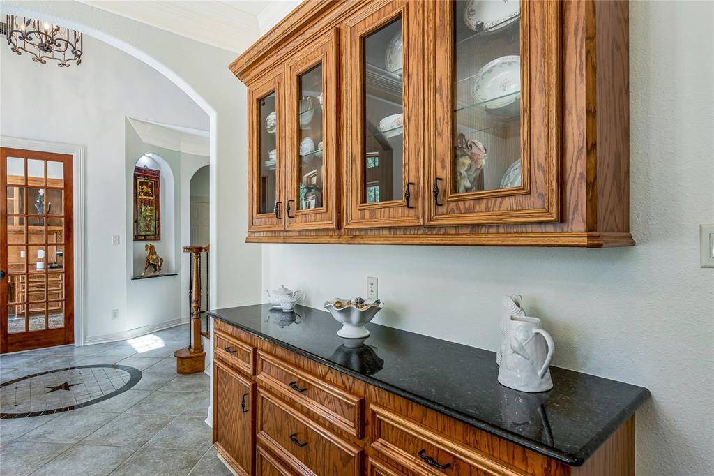This photo showcases a wooden cabinet featuring glass doors, perfect for displaying fine china.