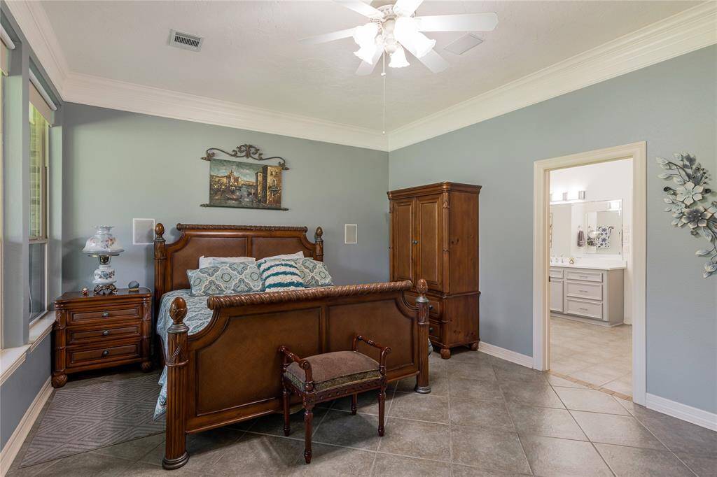 The cozy primary bedroom features large windows with scenic views, and a ceiling fan for comfort.
