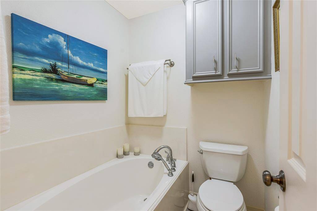 This bathroom features a modern glass-enclosed shower with stylish tile work and a spacious vanity with a large mirror and elegant fixtures.