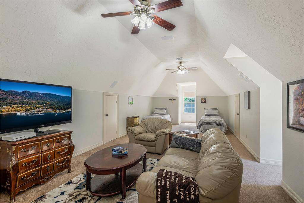 This spacious room features a dormer window to allow ample natural light from. The room's vaulted ceiling and ceiling fans add character and comfort.