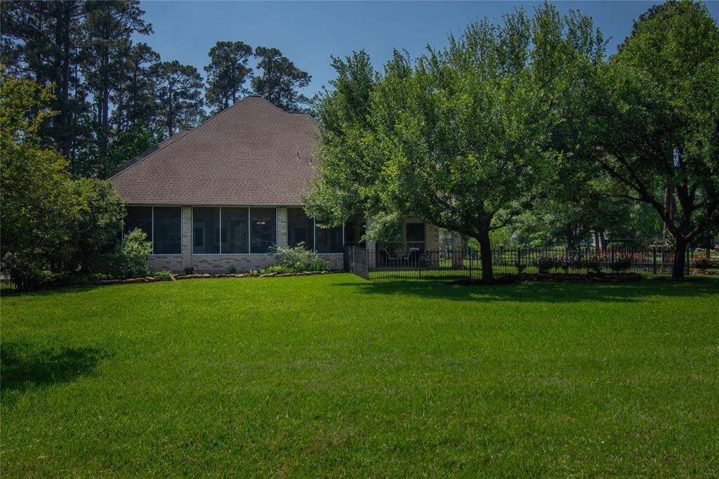 The photo shows a charming home set amidst a spacious, well-maintained lawn. The backyard features mature trees, providing shade and privacy.