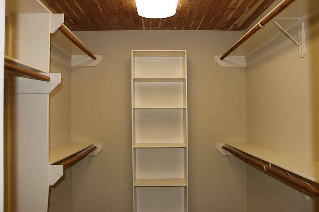 Large master closet with built-ins and cedar ceiling.