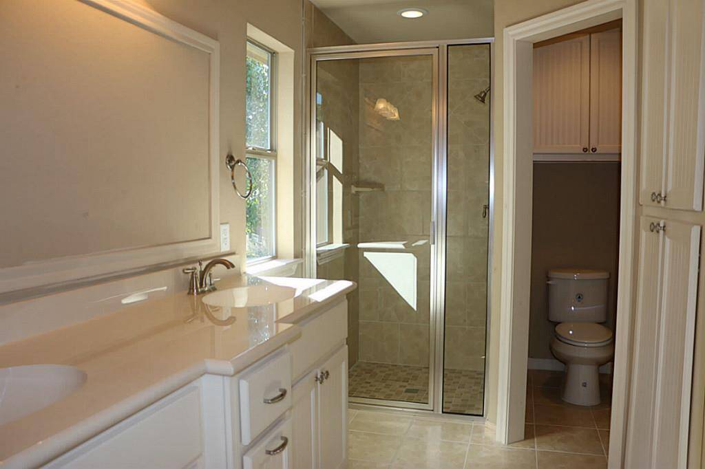 Master bath with double sinks, linen cabinets and  walk-in tiled shower.