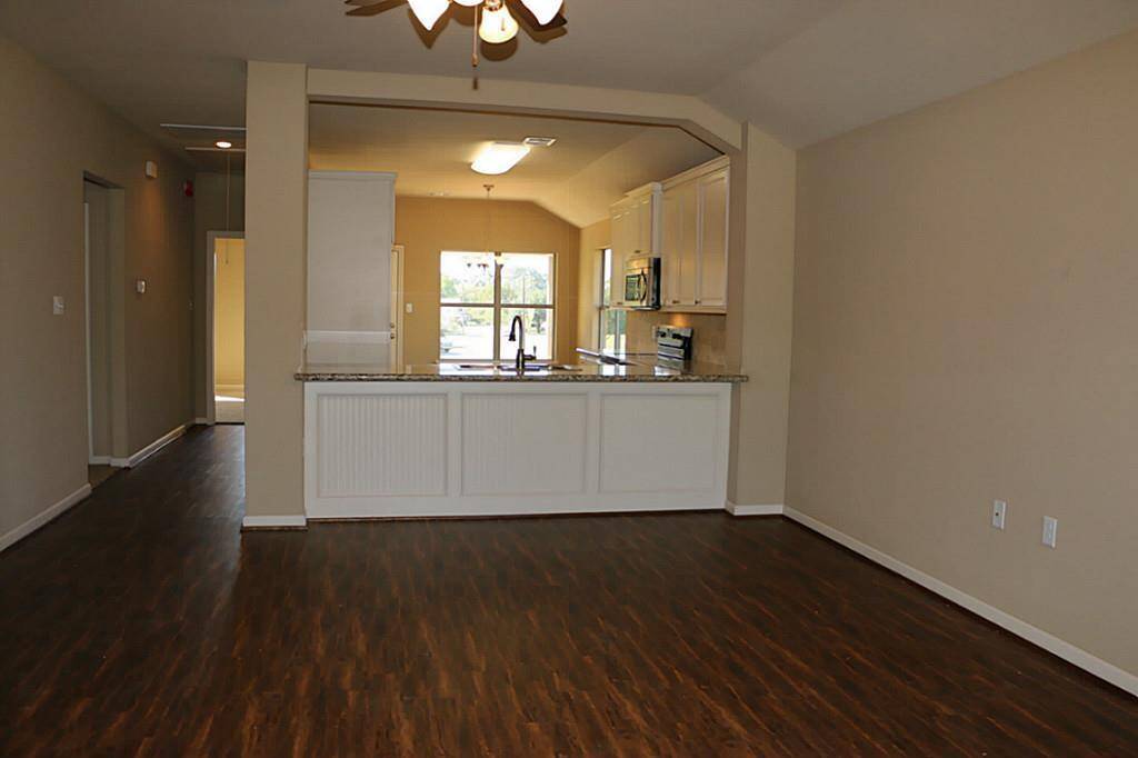 As you enter, the living room is spacious with laminate flooring.