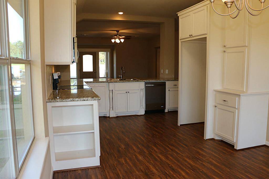 Another view of the kitchen from the breakfast area. Laminate flooring and lots of counter space.