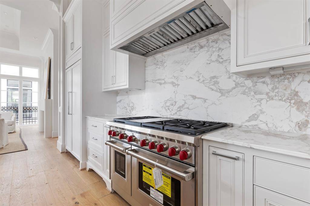 The gourmet kitchen features Energy Star Certified Wolf gourmet appliances including 24" Wolf Microwave, 24" Asko Dishwasher, and this stunning 48" 8-Burner Gas Cooktop (Griddle Optional).