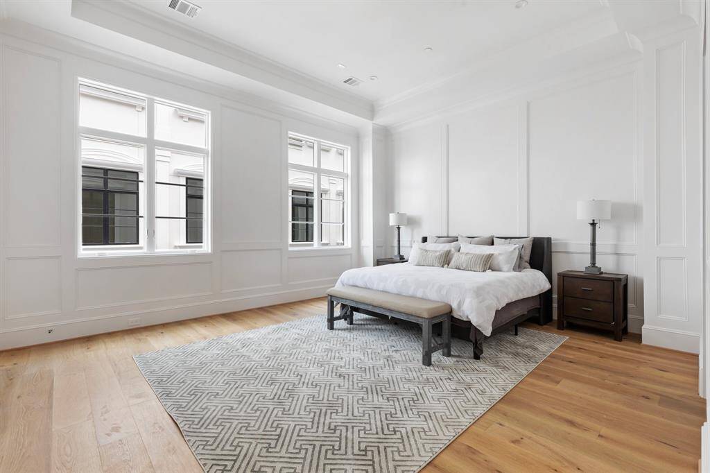 The luxurious master bedroom boasts soaring 12' tray ceiling with elegant floor to ceiling paneling.