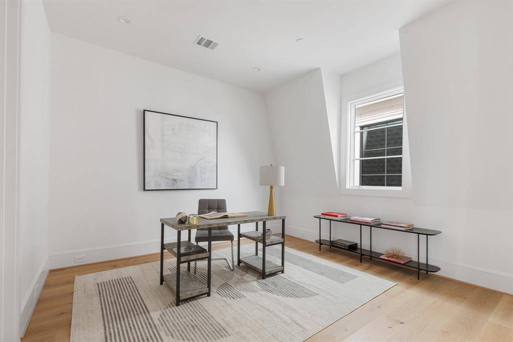 The bedroom features hardwood floors and a built out walk-in closet. (Shown here as a home office).