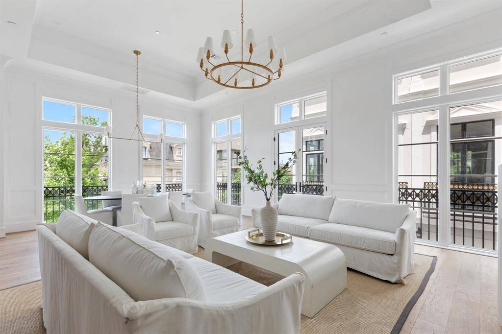 Soaring 14’ ceilings crown the second-floor living room, where a cast stone fireplace and custom millwork create an unforgettable first impression.