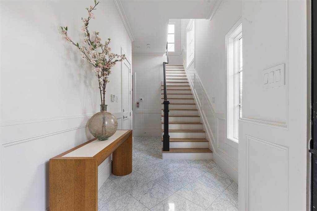 Back downstairs sits the welcoming foyer that seamlessly connects to the staircase, a private ground-floor bedroom, and convenient garage access. This thoughtfully designed space is perfect for greeting guests with its inviting layout and easy flow throughout the home.
