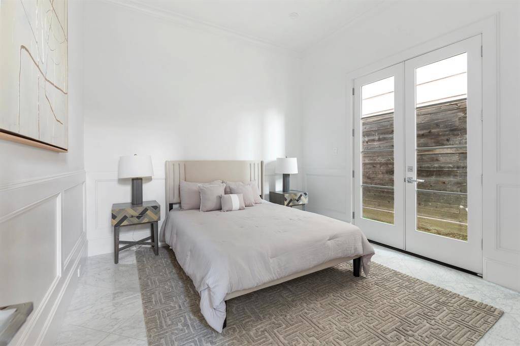 The ground floor bedroom has a large ensuite bathroom with attached closet and french door access to the back grassy area.