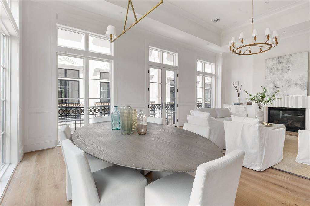 Bathed in natural light, the dining area showcases rich hardwoods and curated designer lighting—perfect for intimate dinners or festive gatherings.