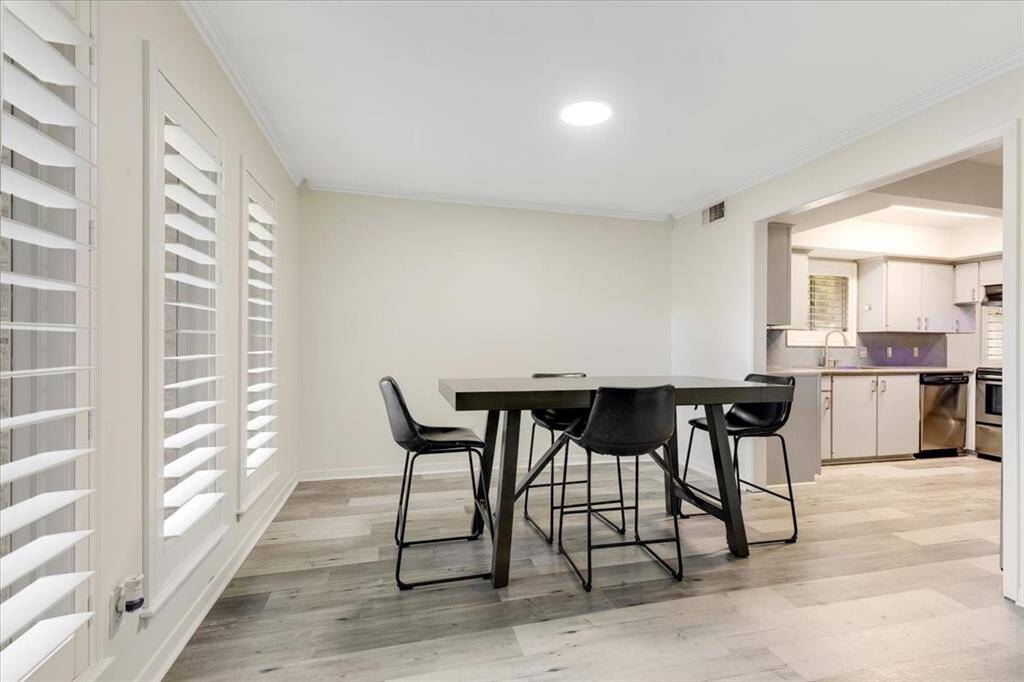 The dining room features fresh paint, new LVP flooring, crown molding and plantation shutters.  The large windows allow lots of natural light into the space.