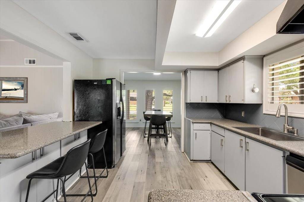 Kitchen updates include stainless steel appliances, Silestone countertops, plantation shutters and LVP flooring.