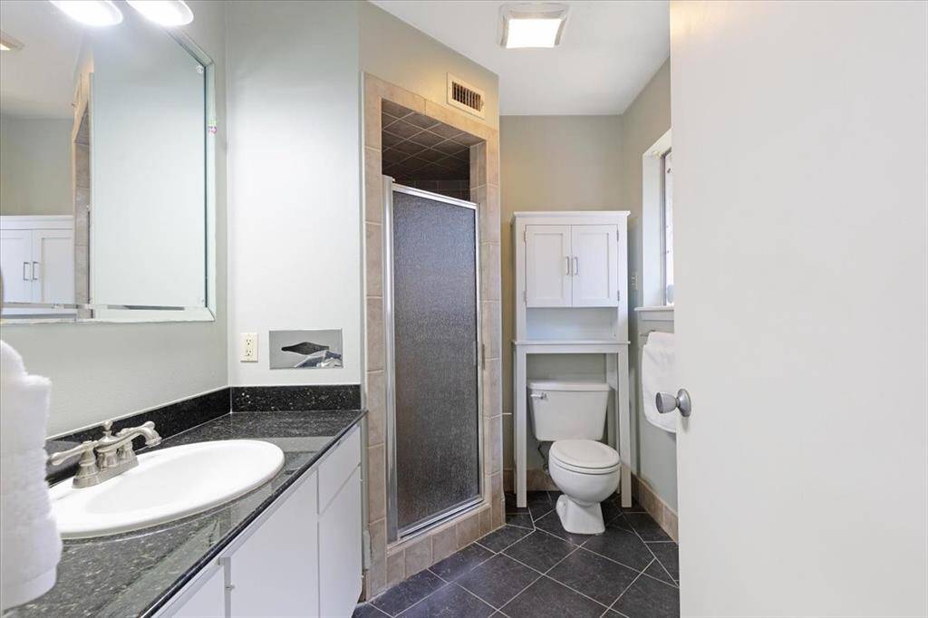 The primary bath includes a walk-in shower and an updated granite vanity.