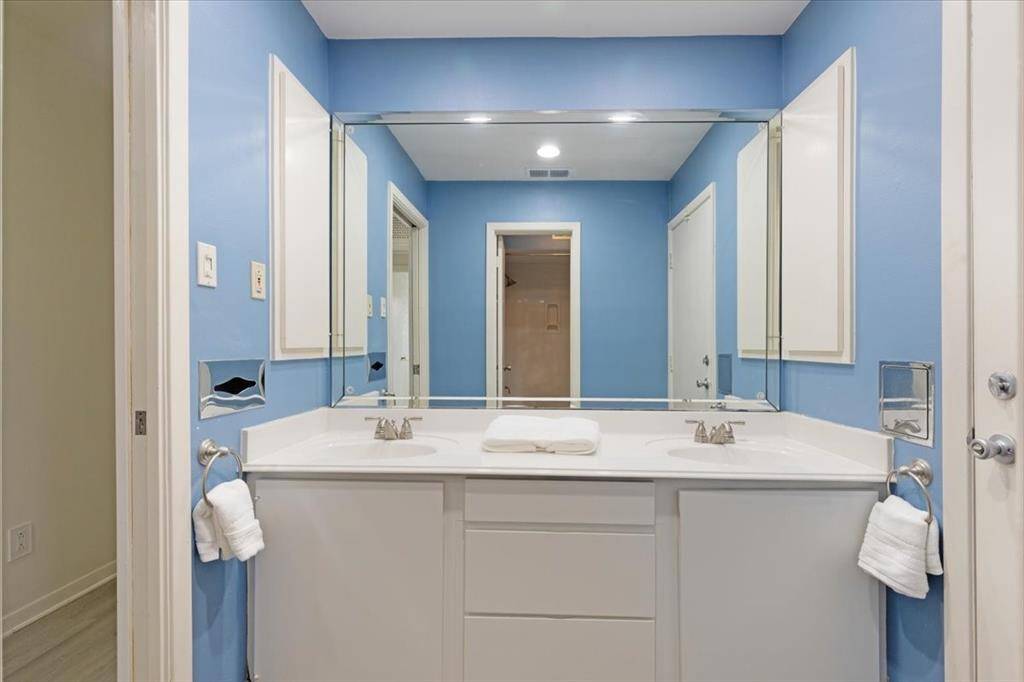 The hall bathroom features freshly painted cabinets and dual sinks.