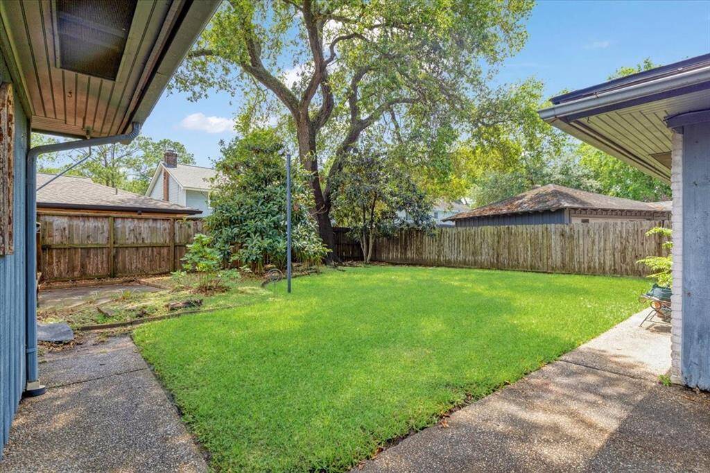 The backyard is spacious, with plenty of trees and a covered patio.