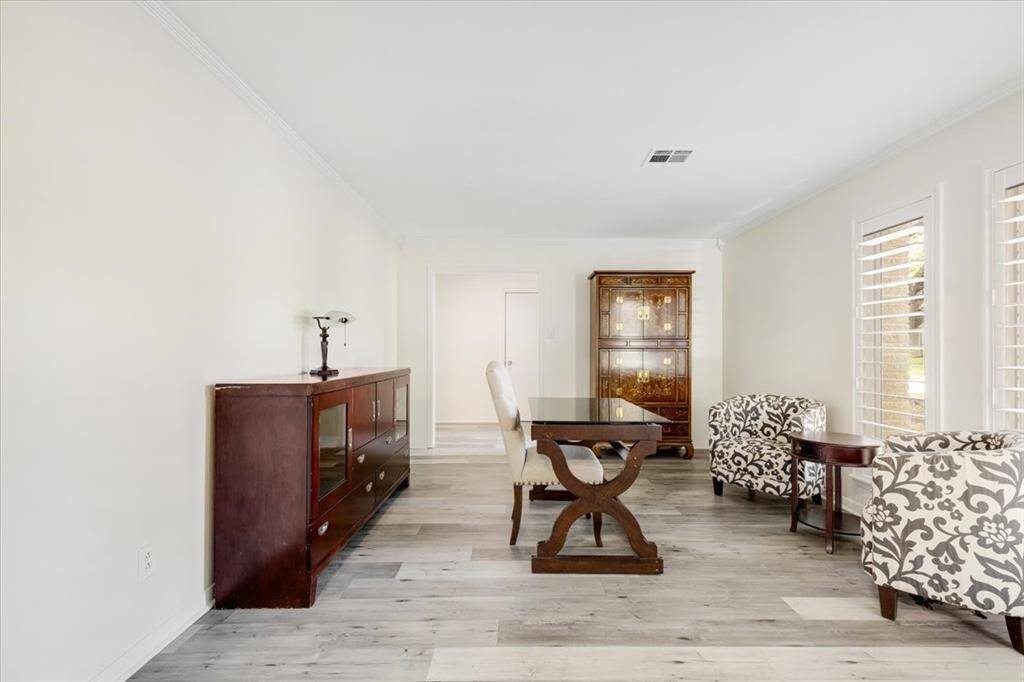 Updates to the formal living room include new LVP flooring, paint and crown molding as well as planation shutters on the windows.