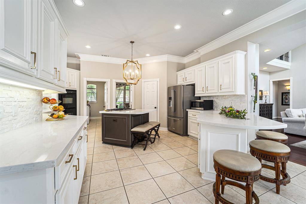 Chef's dream kitchen features ample countertop and cabinet space, breakfast bar seating, and a walk-in pantry.