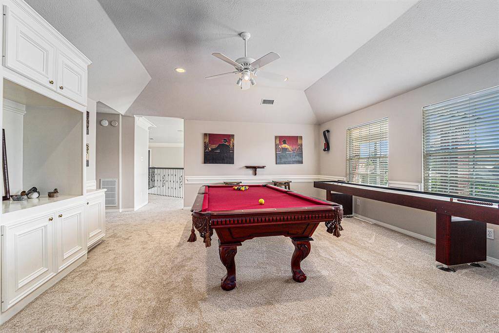 Spacious game room with beautiful custom built-ins.