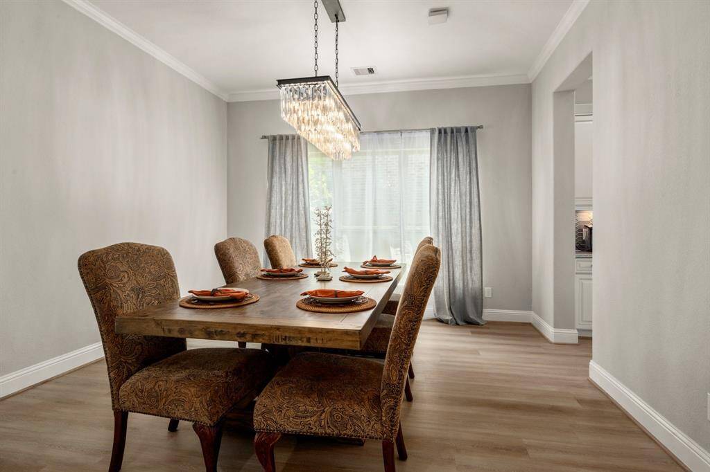 The formal dining room is framed with crown molding and features an upgraded chandelier for added elegance.