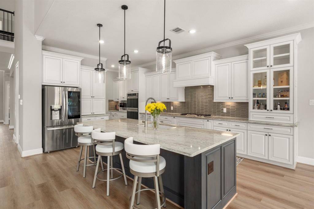 This dream kitchen is equipped with Frigidaire appliances, including a 5-burner gas cooktop, perfect for home chefs.