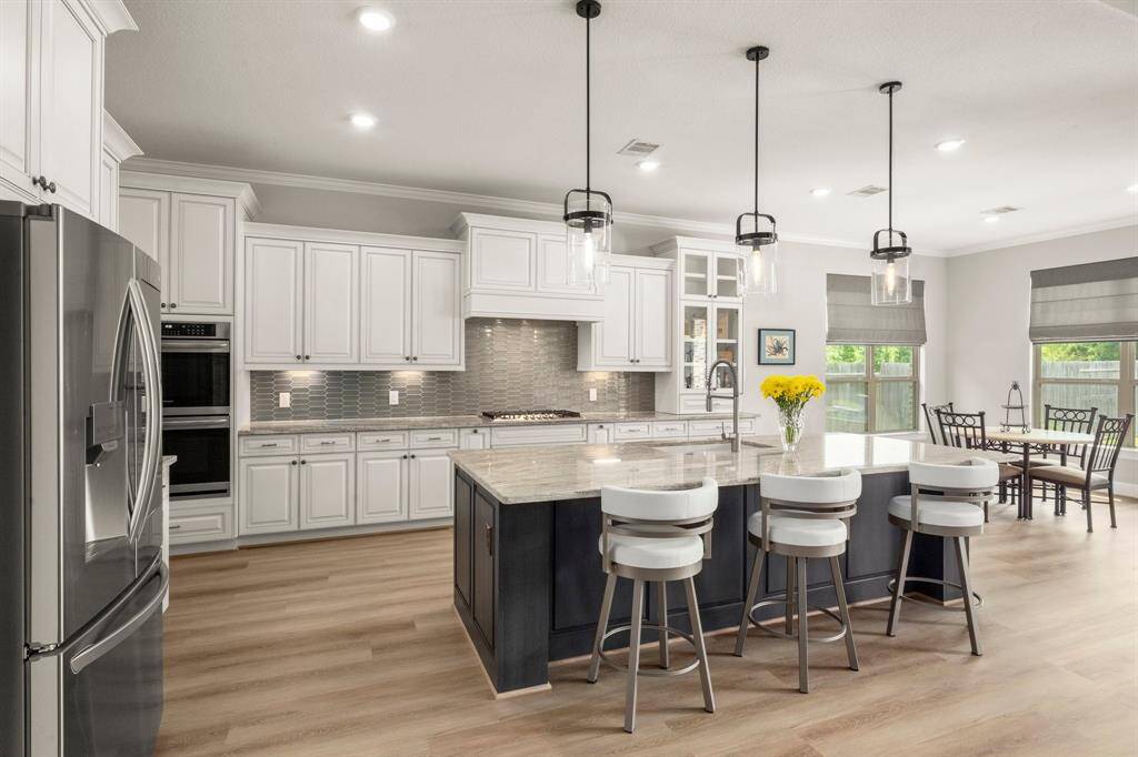 The eye-catching picket mosaic tile backsplash adds texture and elegance, while the pots and pans drawer adds practical luxury.