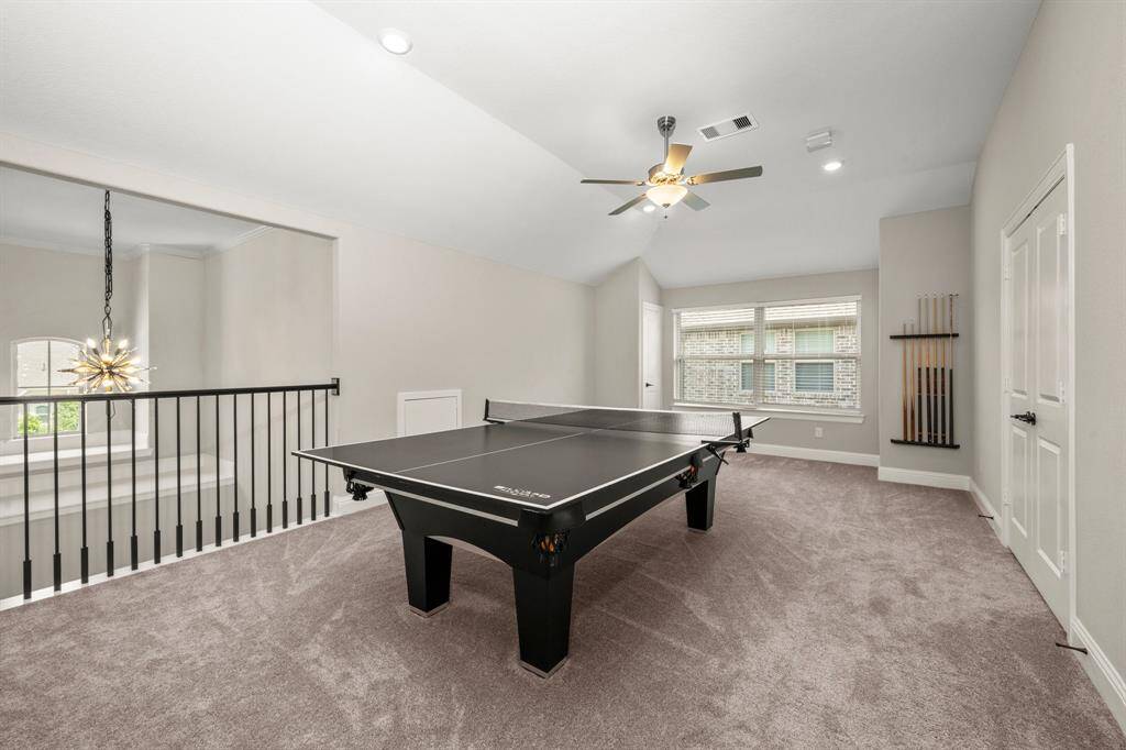 The upstairs game room is spacious enough for a pool table and other recreational fun. Large windows brighten the space, while plush carpet and a ceiling fan keep it comfortable.