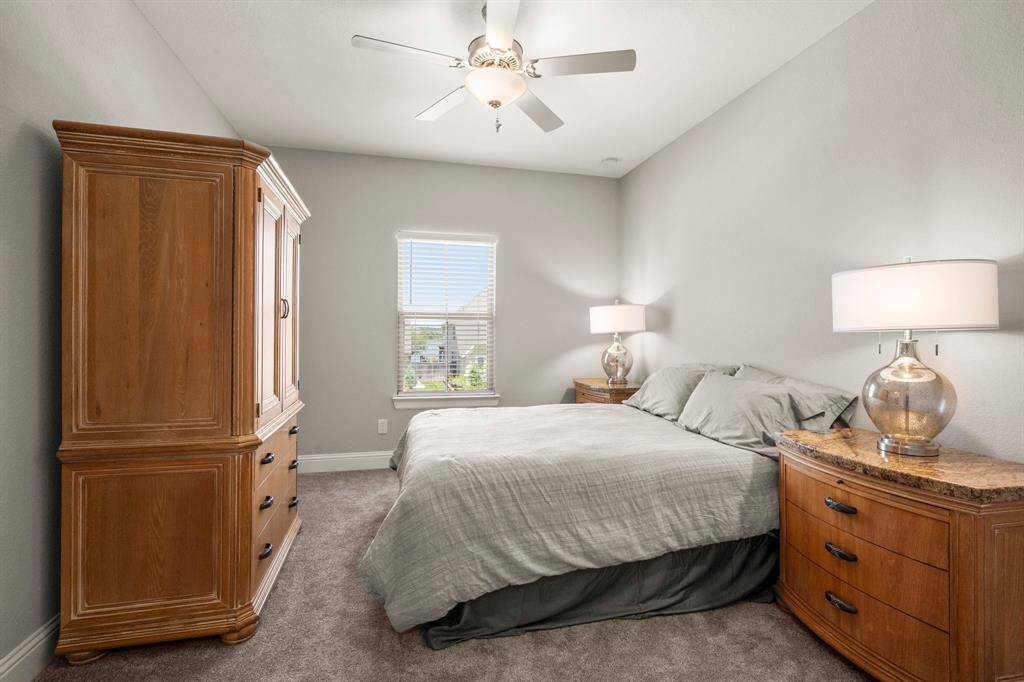 Three well-sized bedrooms upstairs each feature ceiling fans, carpet, and walk-in closets.