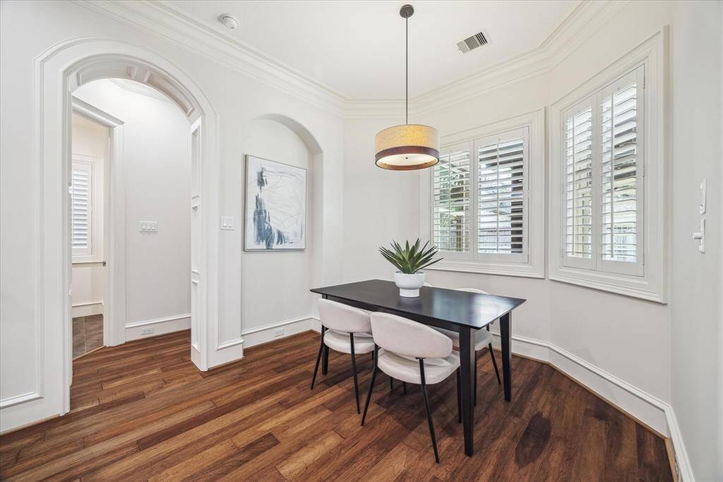 The cozy breakfast room offers a serene spot to enjoy your morning coffee, with large windows overlooking the tranquil back patio.