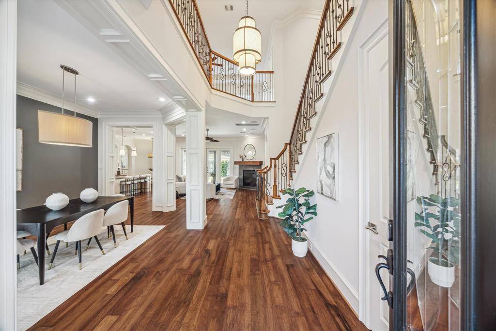 Step inside to a beautifully designed entry with soaring 10-foot ceilings, exquisite millwork, and rich hardwood floors. Detailed wood paneling and custom trim work add a touch of elegance, setting the stage for the home’s timeless style and thoughtful craftsmanship.