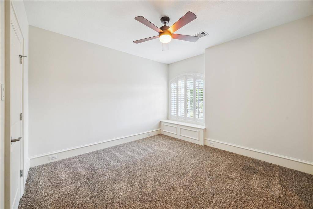 This charming secondary bedroom upstairs features a cozy built-in bench by the window, creating a perfect reading nook or quiet space to relax.