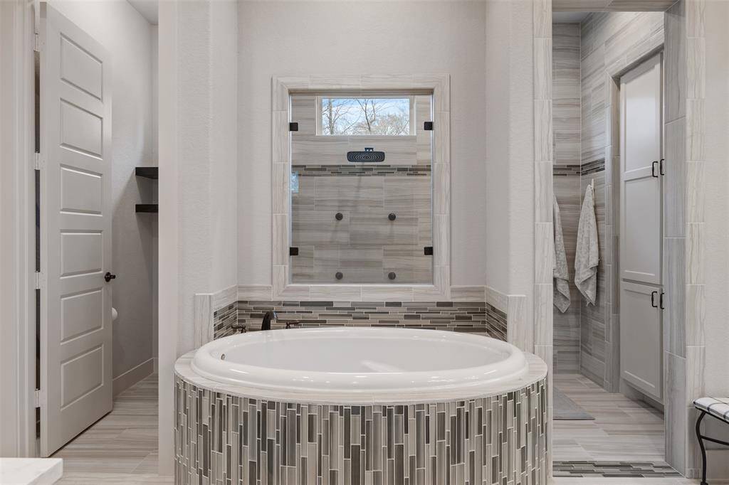 This primary en-suite is a real show stopper! Here you see the soaking tub with window into the shower.
