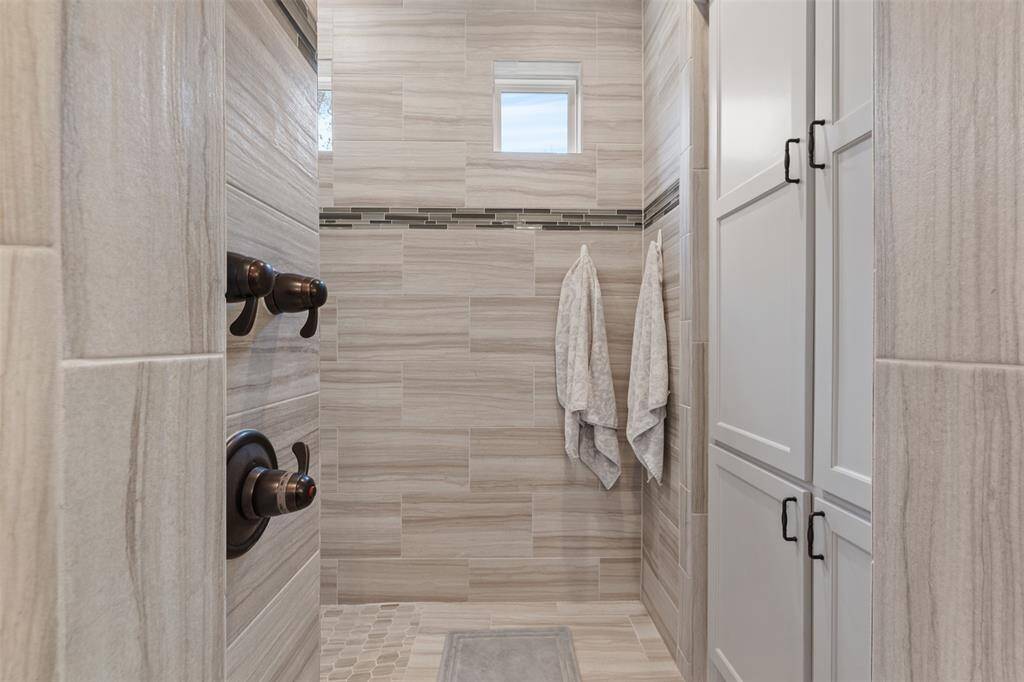 As you walk into the shower, there is additional storage, towel hooks and your shower controls.