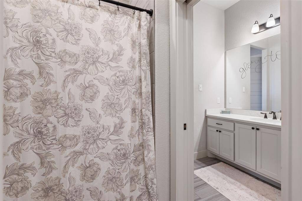 The shower/tub combo and toilet room are separate from the sink areas and shared by the two secondary rooms.