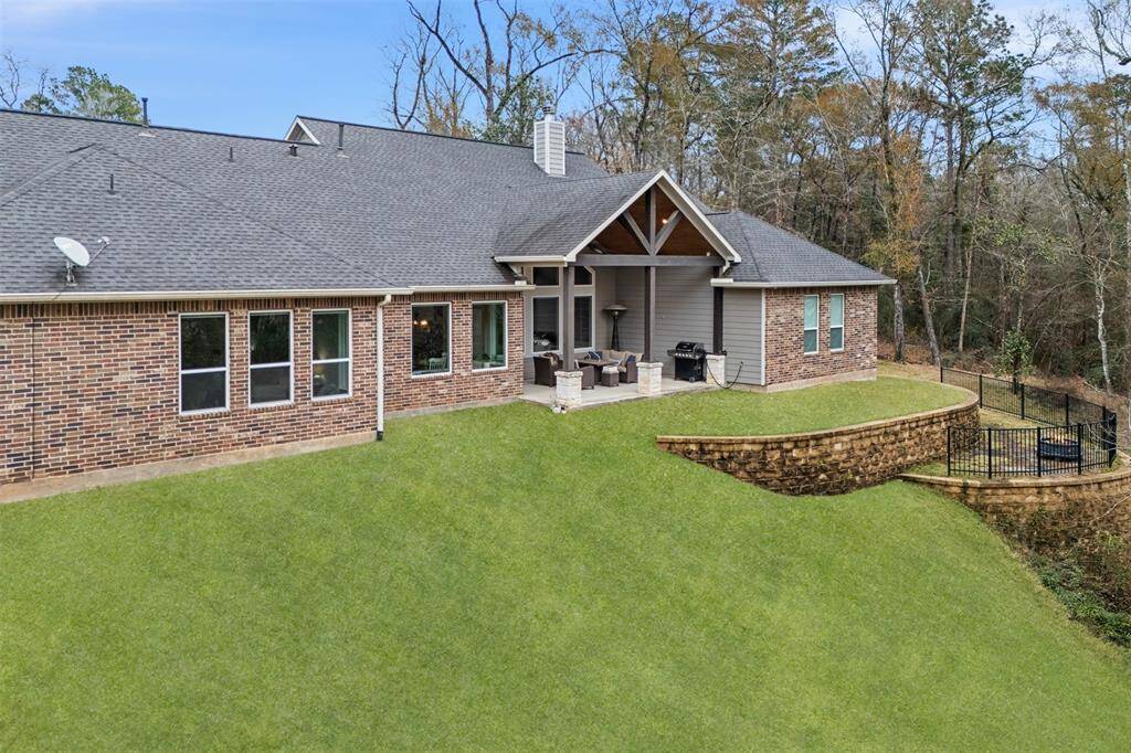 Sloped yard with a built-in retention wall and partial fencing.