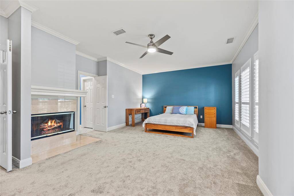 How perfect is this primary space? Spacious and bathed in natural light. The fireplace and estate shutters add that luxury flare. Your private retreat awaits, promising pure relaxation.